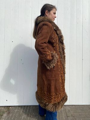 Brown suede coat with fur-trimmed details.