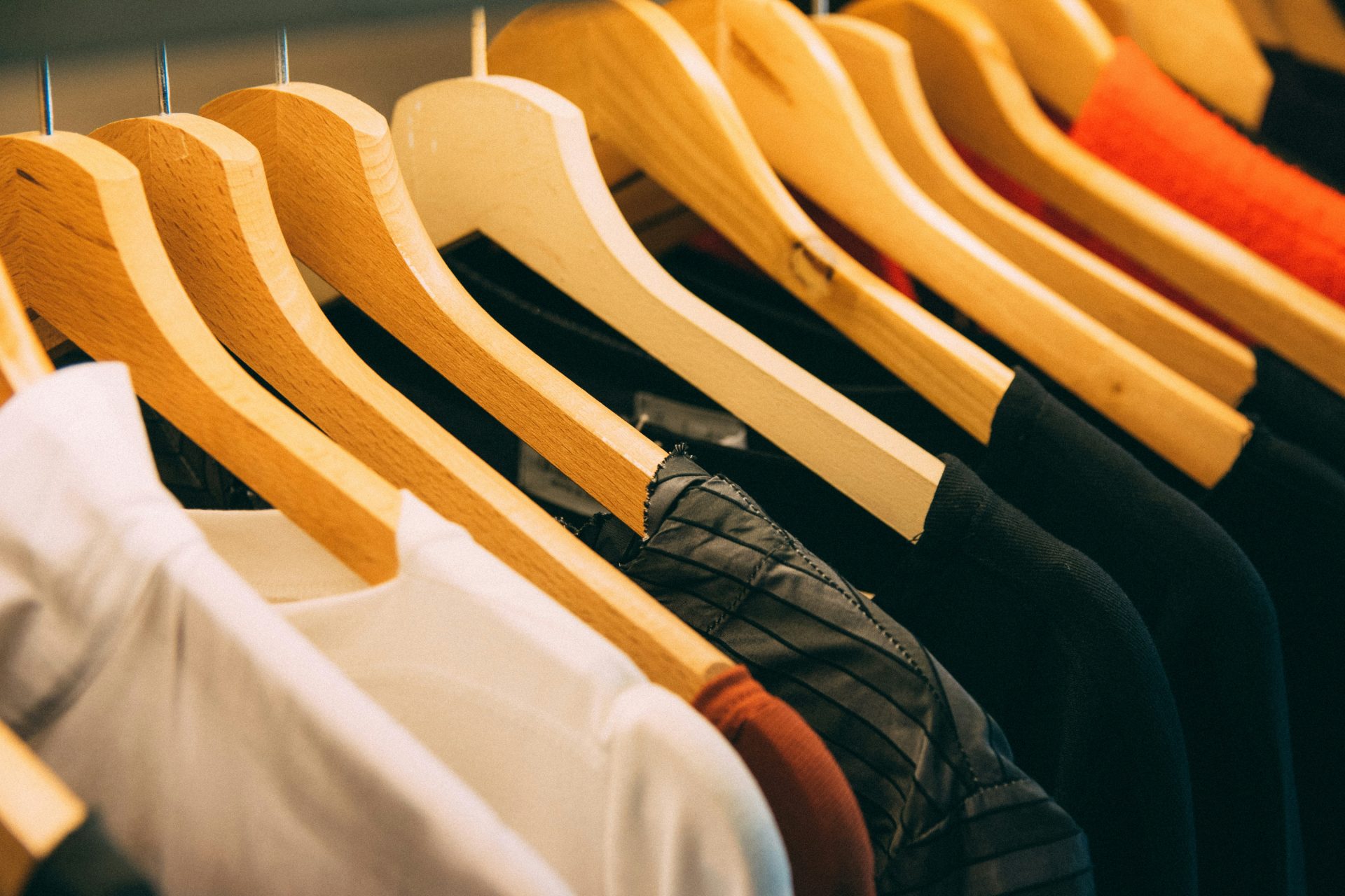 Wooden hangers holding neatly organized clothes