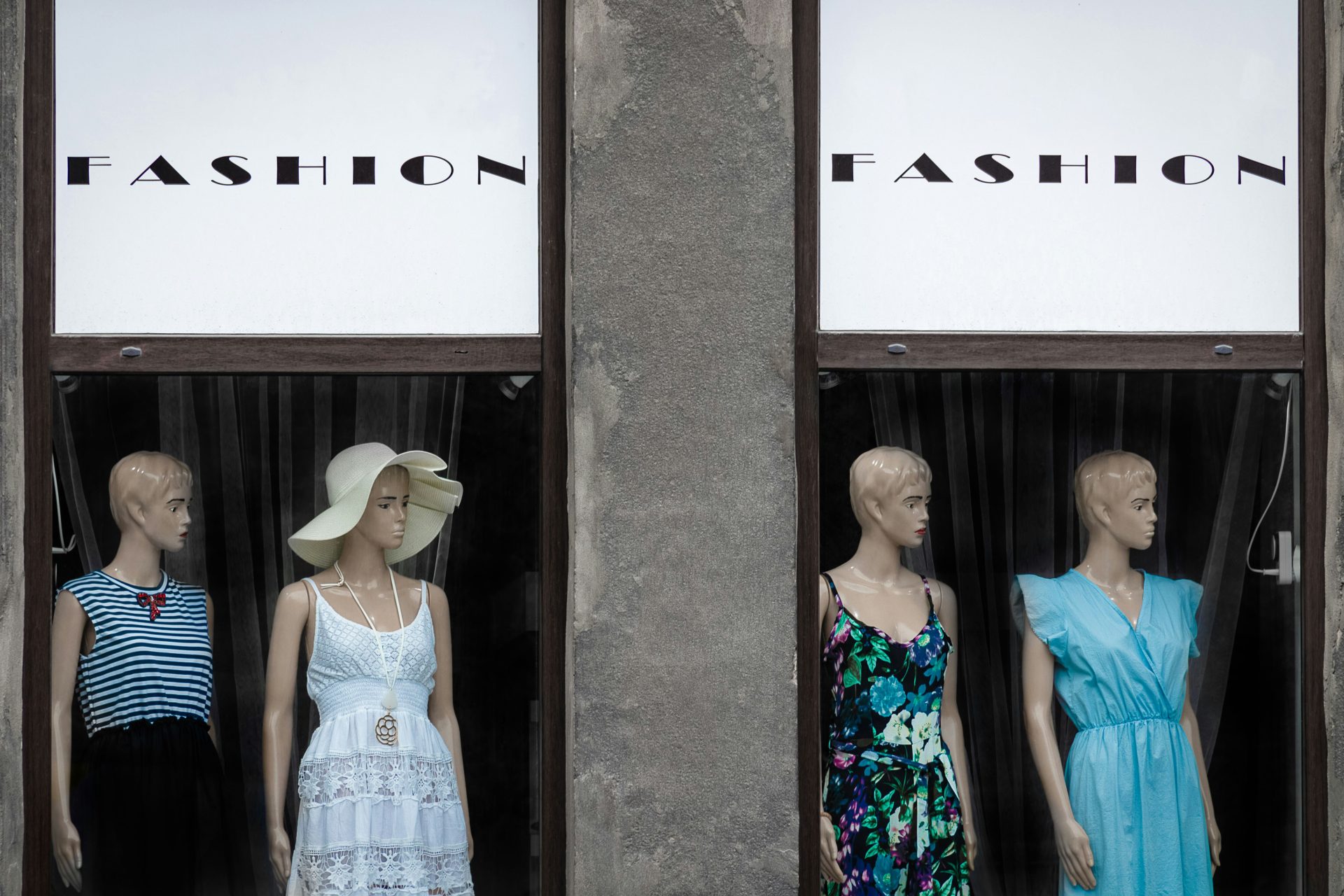 Mannequins displaying summer dresses in fashion window